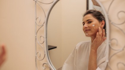 ragazza che si spalma la crema sul viso di bava di lumaca purissima sul viso in bagno a Roseto Degli Abruzzi